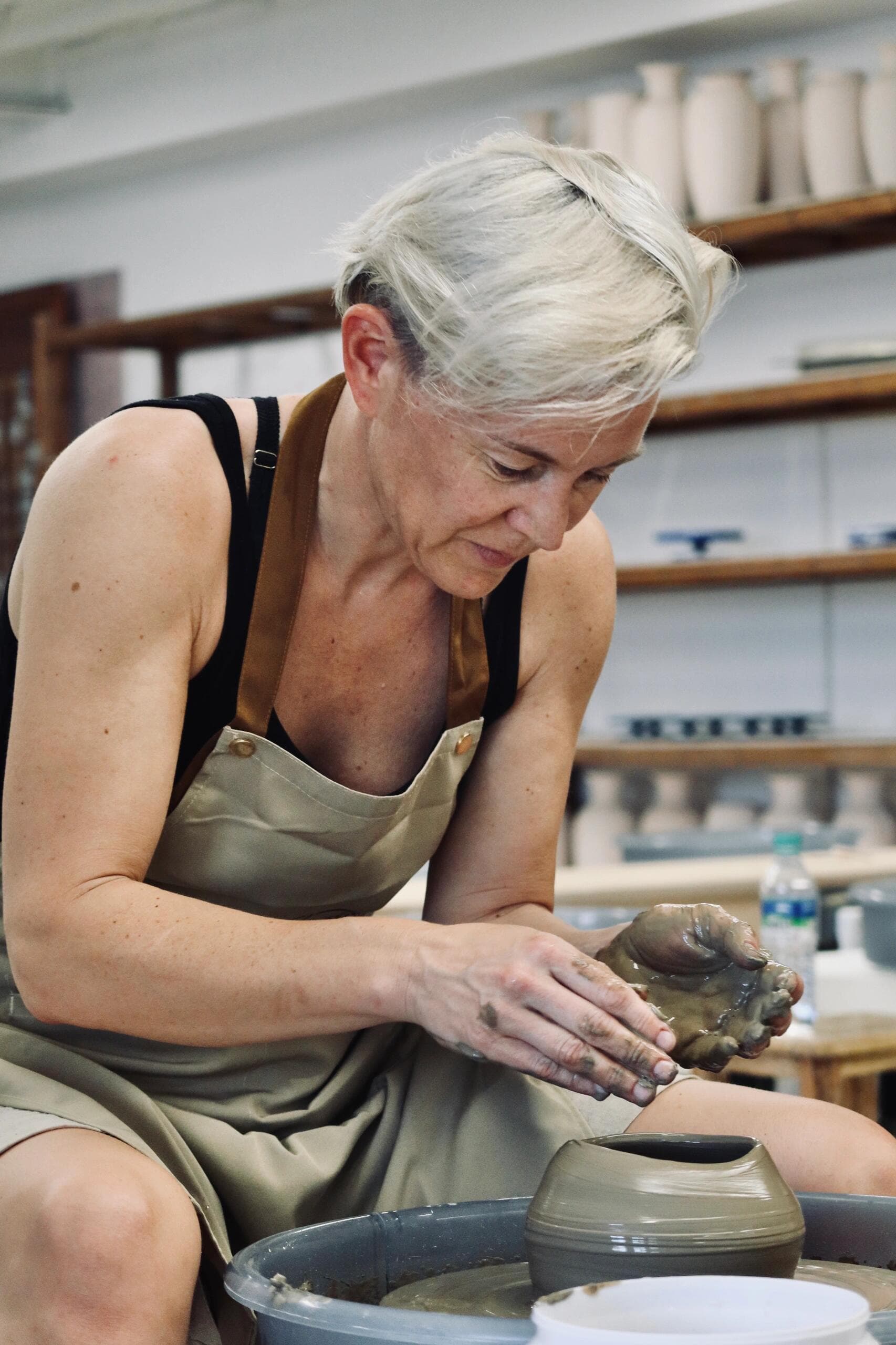 A traveler shaping clay during a pottery experience in Jingdezhen