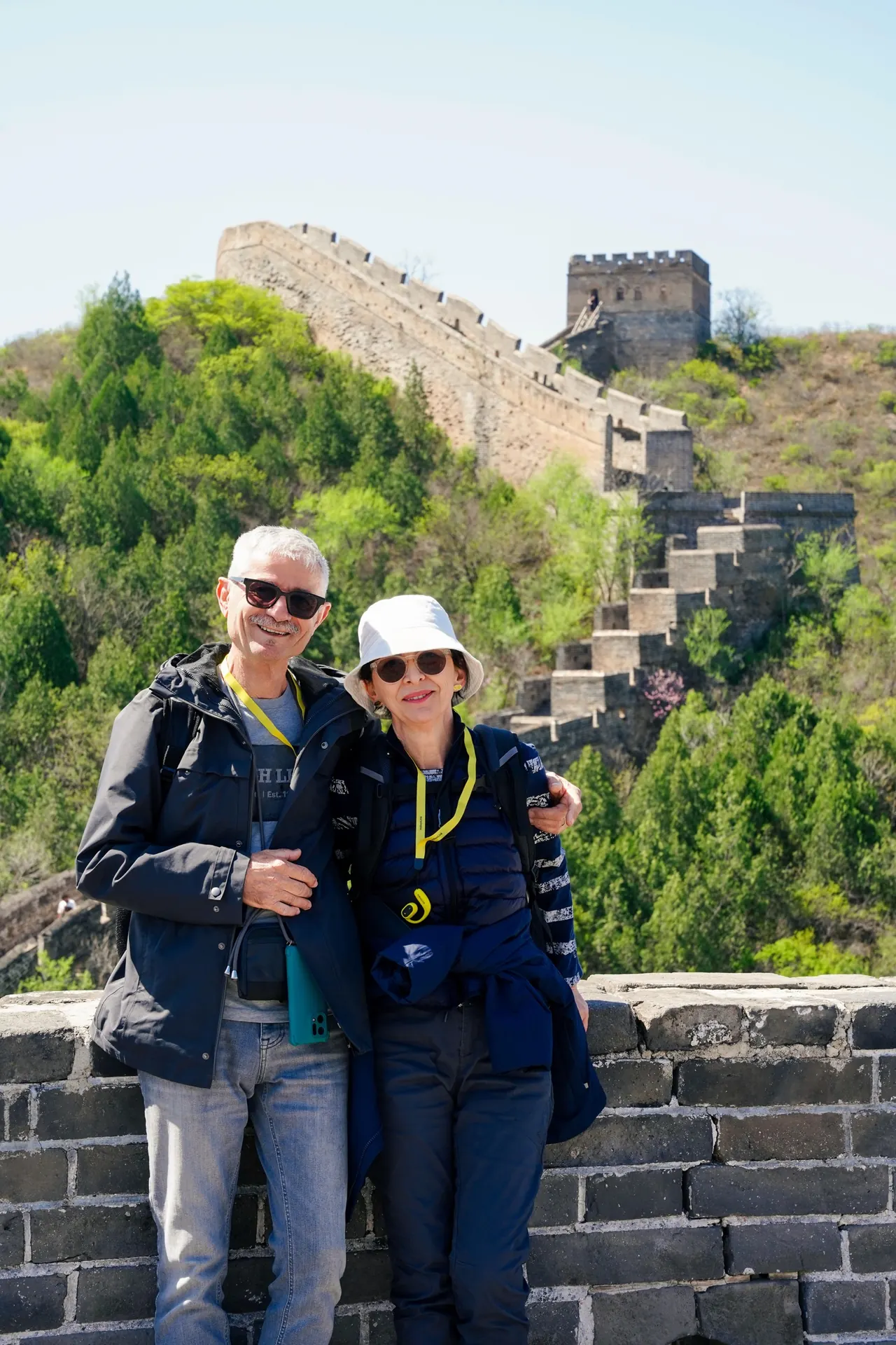 Two travelers beside the Great Wall and wooded hills near Beijing